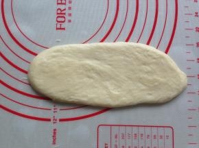 大面团擀成椭圆形，卷起，再擀长并卷起。