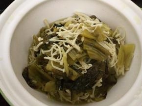 捞出酸菜和金针茹放入砂锅（或大的餐具）中。