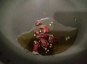 平底锅中加入适量食用油，放入切段的干辣椒，小火把油烧热。