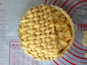 将苹果馅放进去，尽量铺满。将编织好井字型的放在上面，切出多余的部分，留出1/3。