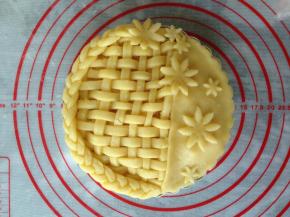 擀出一块小的派皮铺在1/3处，去掉多余的派皮。用花型模具压出大小花朵放在上面。