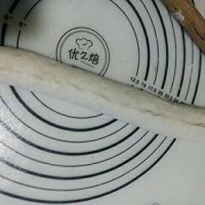 用手拍成面片提起面片长边向下翻折到1/3处，把边压实。再把下部的面片边压薄后提起抻长向上卷折，接口处用手捏紧。（捏不紧烤制过程中会裂开）(用的原味法棍的相片)