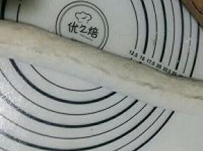 用手拍成面片提起面片长边向下翻折到1/3处，把边压实。再把下部的面片边压薄后提起抻长向上卷折，接口处用手捏紧。（捏不紧烤制过程中会裂开）(用的原味法棍的相片)