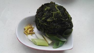 准备好的原料：枸杞芽放水中化冻，挤水(鲜枸杞芽焯水后直接用)，姜切丝，葱切段或切丝。