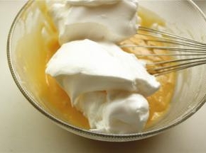 挖一些蛋白霜到蛋黄糊里。