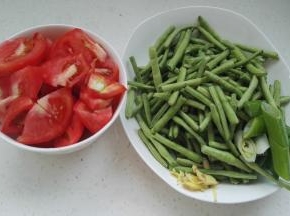 准备好的原料。豆角用手掰成段，姜切丝，葱切段。西红柿切小块。