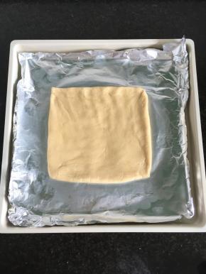 6.将面团放在铺了锡纸的烤盘里，借助刮板整型成一个方形，厚度1厘米左右；