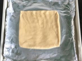 6.将面团放在铺了锡纸的烤盘里，借助刮板整型成一个方形，厚度1厘米左右；