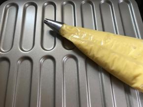 裱花袋装入中号圆形花嘴将面糊装入裱花袋中。