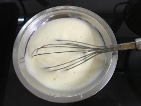 、将煮好的糖水关火，倒入打发好的蛋黄，继续用打蛋器搅打5分钟左右，放凉备用。