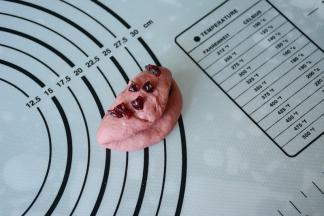 在将红色面团对折一下，再次加入少量蔓越莓，包好滚圆。