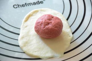 将红色面团包入白色面团中。