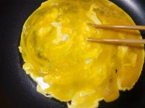 把鸡蛋磕入碗里，加入一点点盐调味。倒入锅里用油炒一下