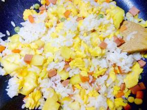 小火翻炒，让菠萝的酸甜味道渗入米饭和蛋中，再大火翻炒几下。