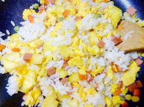 小火翻炒，让菠萝的酸甜味道渗入米饭和蛋中，再大火翻炒几下。