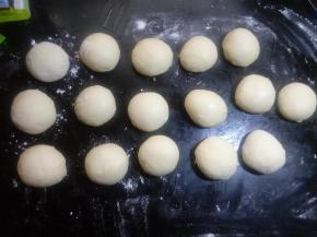 把分好的面团拍扁排气揉圆，不包馅可以直接放入烤盘。包馅料盖上保鲜膜松驰10分钟。