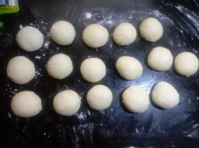 把分好的面团拍扁排气揉圆，不包馅可以直接放入烤盘。包馅料盖上保鲜膜松驰10分钟。