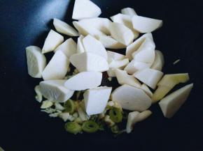 锅中加入切好的葱，蒜，炒香，有香味后加入切好的茭白块煸炒。