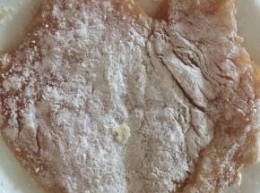 将腌制好的鸡胸肉两面裹上干淀粉。