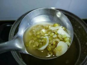 加入冰糖，再次开火煮开，转中火煮十分钟，焖一会，舀一勺看看绿豆已开花即可