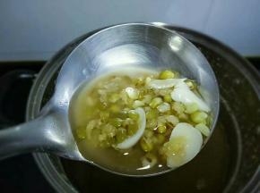 加入冰糖，再次开火煮开，转中火煮十分钟，焖一会，舀一勺看看绿豆已开花即可