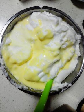 将蛋黄糊全部倒入蛋白霜盆中，翻拌均匀