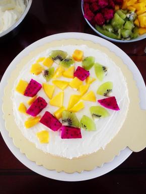 将淡奶油装入裱花袋中，裱花台上放一片蛋糕胚，抹一层淡奶油后，放一层水果，再抹一层淡奶油