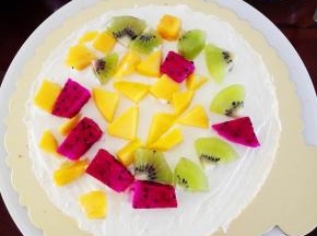 将淡奶油装入裱花袋中，裱花台上放一片蛋糕胚，抹一层淡奶油后，放一层水果，再抹一层淡奶油