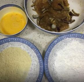 取出腌制好的鸡肉，鸡蛋打散，用两个盘子分别盛面包糠和生粉