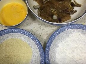 取出腌制好的鸡肉，鸡蛋打散，用两个盘子分别盛面包糠和生粉