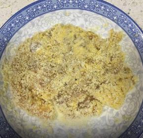 鸡胸肉取出抖掉洋葱和姜丝，先两面都裹上生粉，接着滚一圈鸡蛋液，然后裹上面包糠