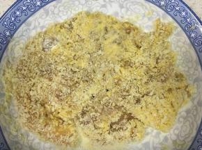 鸡胸肉取出抖掉洋葱和姜丝，先两面都裹上生粉，接着滚一圈鸡蛋液，然后裹上面包糠