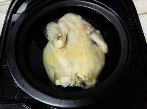 把鸡捞出，放入电饭煲中，加入没过鸡的清水