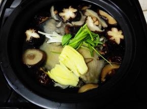 再将泡发好的香菇洗净，姜块拍开，葱洗净打结，全部放入锅中