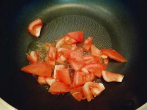 番茄洗干净切小块，锅中放入食用油，加入切好的蒜炒香，放入切好的番茄煸炒，炒至番茄变软。