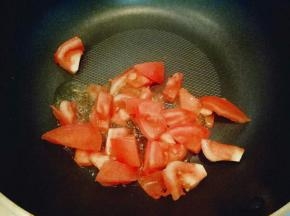 番茄洗干净切小块，锅中放入食用油，加入切好的蒜炒香，放入切好的番茄煸炒，炒至番茄变软。