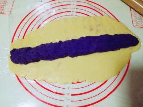 用擀面杖擀薄片，将紫薯搓成长条，放在薄的面皮上。