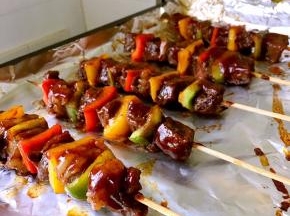 9，烤好的牛肉串再刷少许烧烤酱即可开吃。