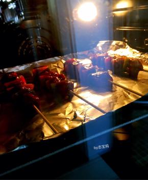 8，烤盘里垫上锡箔纸，把穿好的牛肉串整齐地码入烤盘中，用毛刷沾少许食用油均匀的刷在牛肉串表面，烤箱预热至200度，把装了牛肉串的烤盘放入烤箱中层，上下火烘烤15分钟左右，烘烤中途拿出烤盘，在牛肉串上刷上一层烧烤酱，再烤几分钟即可出炉。