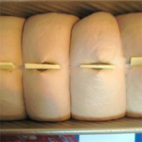 面团发至九分满，用剪刀在面团表面剪四个口（或者用锋利的刀在表面划一刀），在裂口处放上黄油片（配方外黄油）；