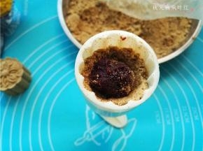 将豆沙馅放入，上面再铺上绿豆粉，压实；