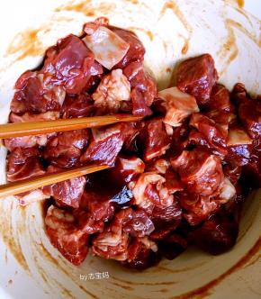 3，牛肉块装碗里，放少许盐拌一下，倒入烧烤酱腌制两个小时。