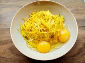 将南瓜丝放入大腕中，打入2个鸡蛋搅拌均匀