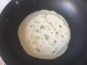 转动锅子，摊成一个圆饼。转小火