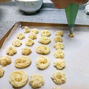 烤盘铺油纸，开始挤吧，这可是个体力活。我用的樱花花嘴。如果把裱花袋和烤盘垂直直接挤一下出来就是个薄薄的樱花形状。我是稍微向下摁压并且轻轻抖动手腕挤，出来就是这种层叠的花纹。期间挤累了我就挤了几个圈圈。反正自己吃，随意发挥吧。挤成长条也可以啊，反正味道也不会变。