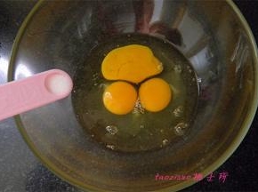 将三个鸡蛋打入大碗里，放入2克食盐；