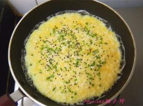 在蛋液将要凝固时，撒上黑芝麻和香葱末（这期间一直用小火煎制）；