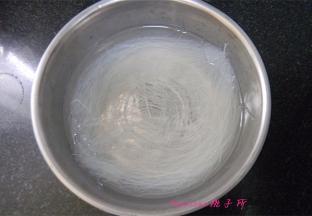 将粉丝用温水泡透，切成段；