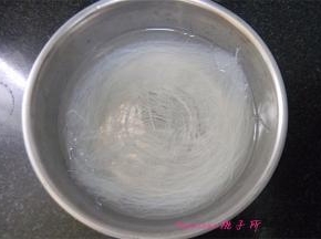 将粉丝用温水泡透，切成段；