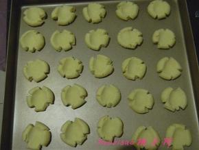 取出面团后，取一小块揉成小圆球放在烤盘上，用大拇指压扁，饼干会有自然的裂纹；